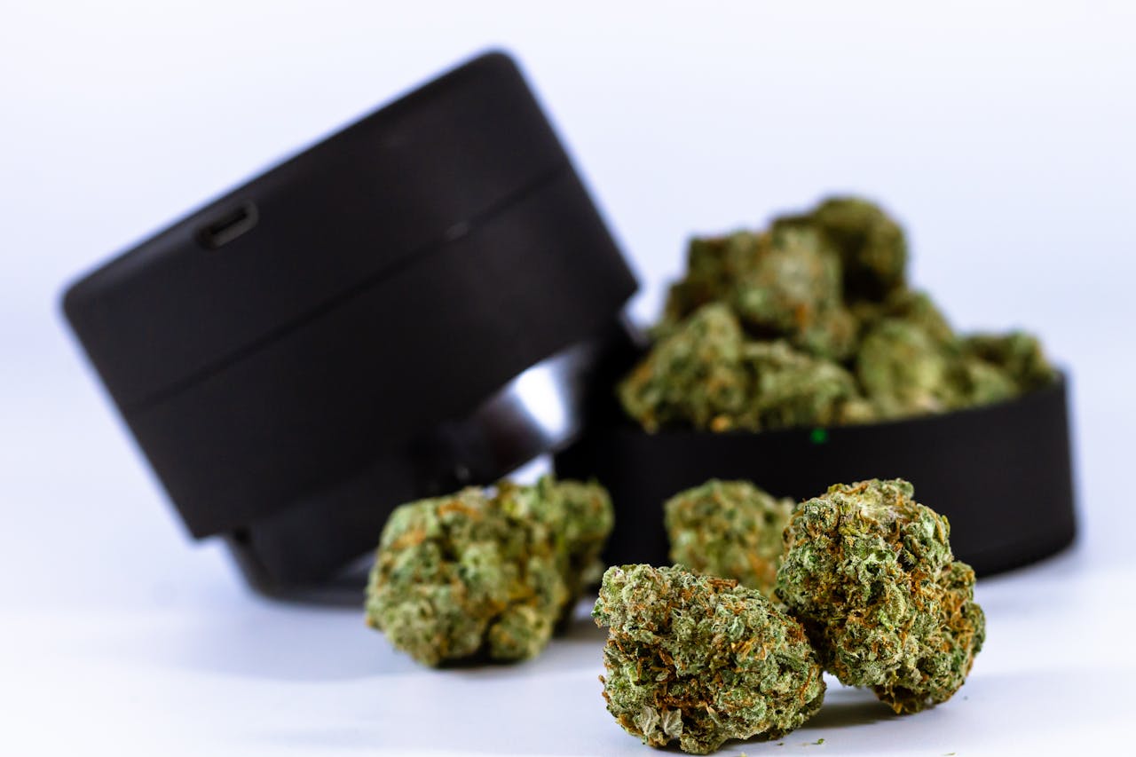About Close-up of cannabis buds with a black grinder, showcasing their texture and color.